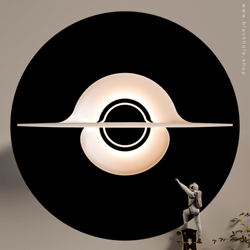 A Black Hole shaped wall lamp mounted on a wall & emitting warm white  light.